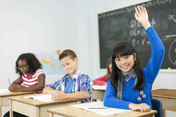 middle school girl smiling with hand raised